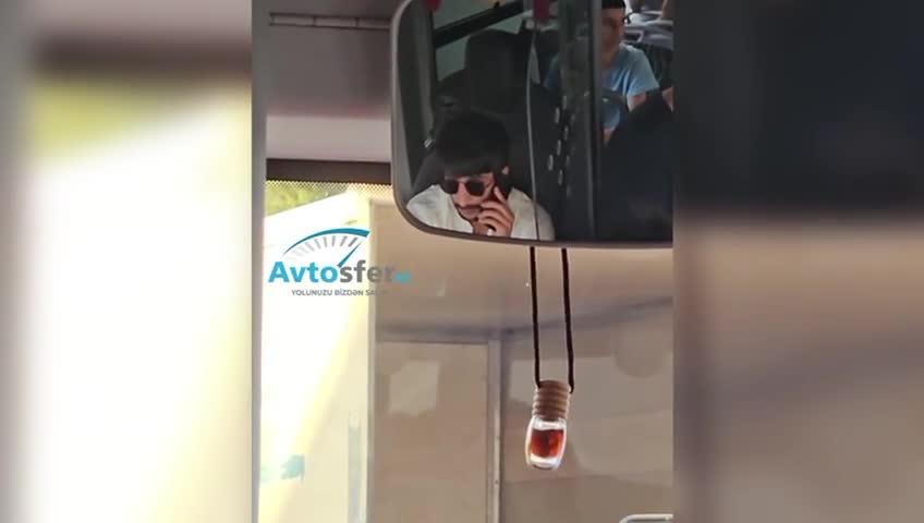 Yol boyu siqaret çəkib telefonla danışan sürücü