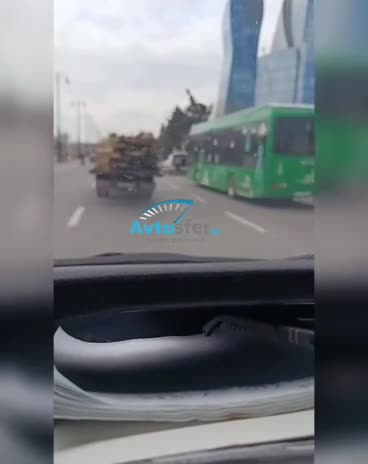 Evakuatorla taxta-şalban daşıyan sürücü