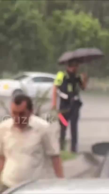Sürücü yağışlı havada xidmət aparan polisə çətir verdi – VİDEO 